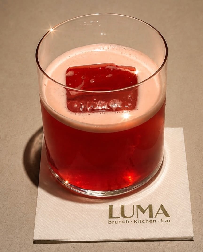Cocktail του LUMA σε ποτήρι πάνω σε χαρτοπετσέτα με το λογότυπο